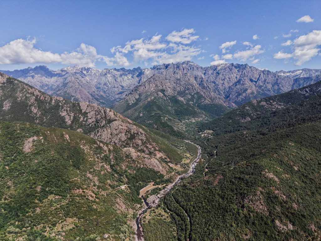 Valle fluvial y cumbres nevadas, desde el aire sobre las montañas de Córcega