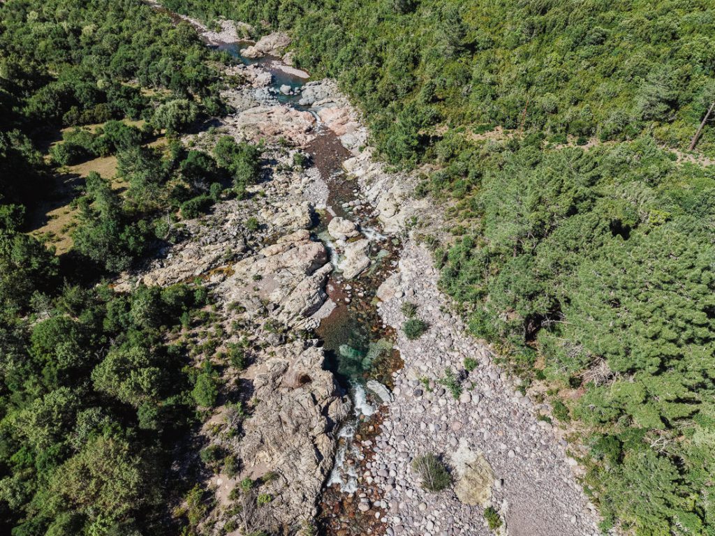 Lecho pedregoso con pequeñas cascadas entre el maquis, desde el aire, en Córcega