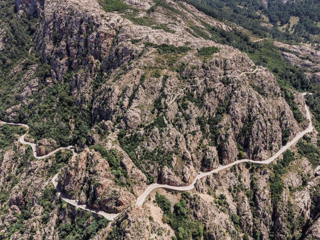 Curvas cerradas sobre una loma gris, desde el aire, en Córcega