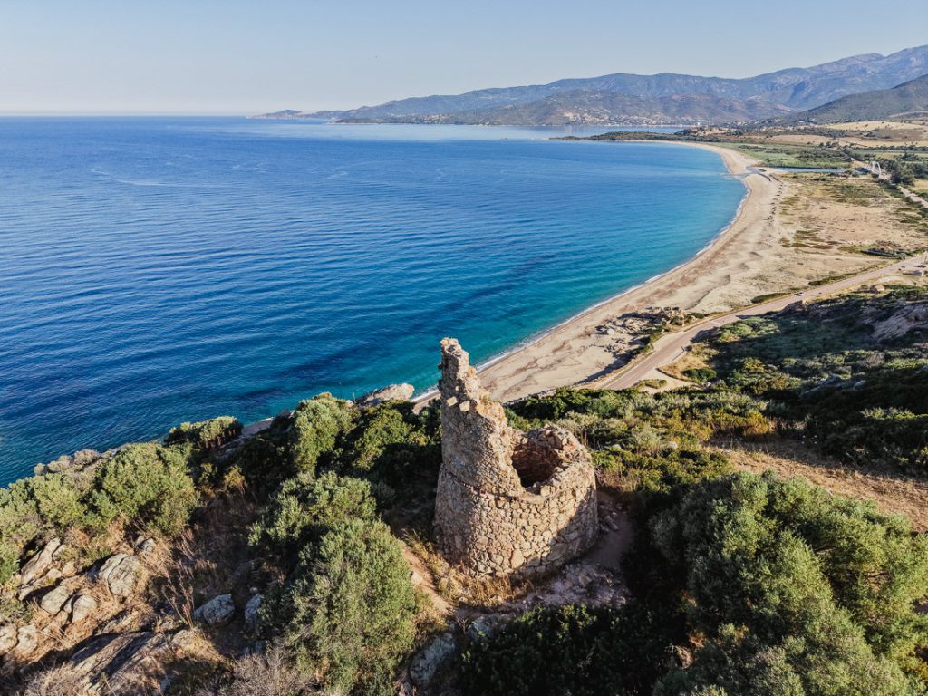 Torre vigía redonda sobre una larga playa, desde el aire, en la costa de Córcega