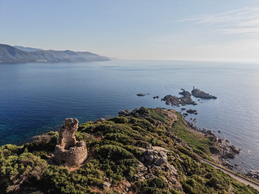 Torre vigía en un promontorio, con rocas en el mar, desde el aire, en la costa de Córcega