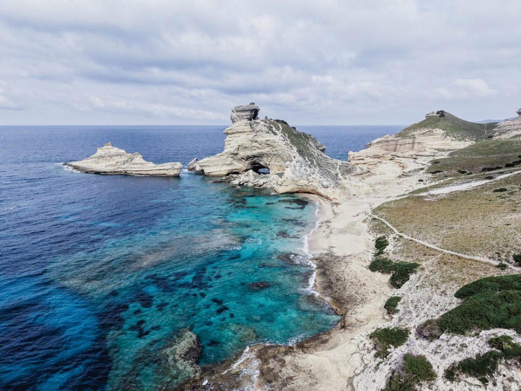 Roca caliza en forma de seta y agua turquesa, desde el aire cerca de Bonifacio en Córcega